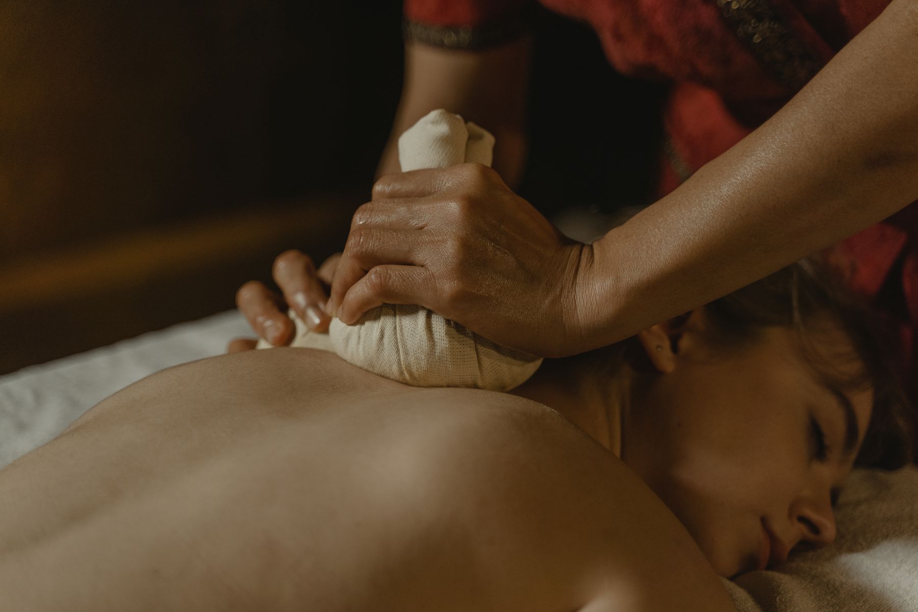 Warm herbal compress massage at the spa