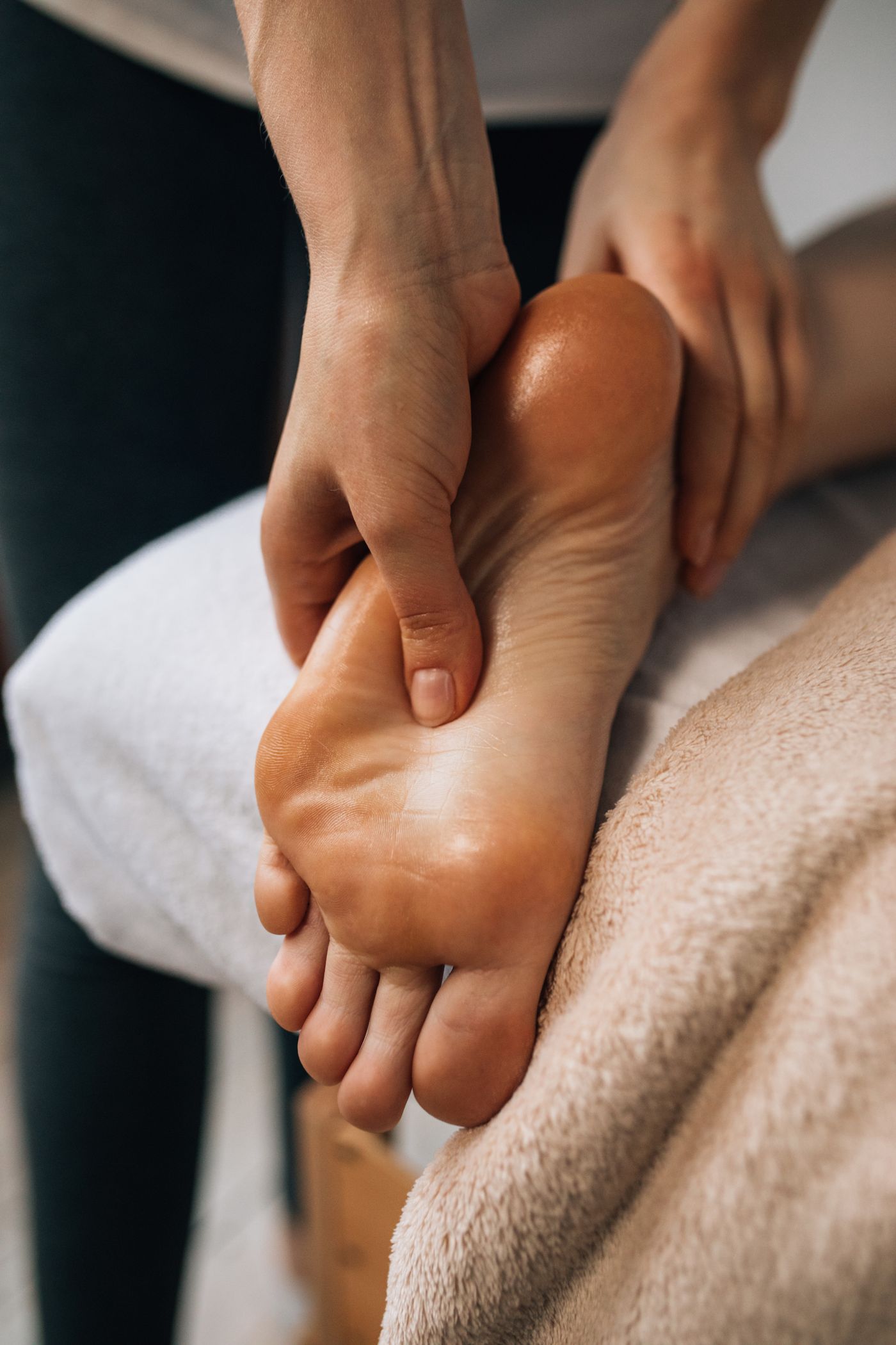 Close-up of hands working pressure points on a foot